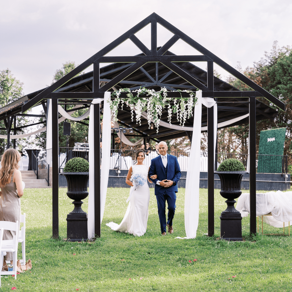 Bride and groom saying vows beneath floral arch in Gallatin