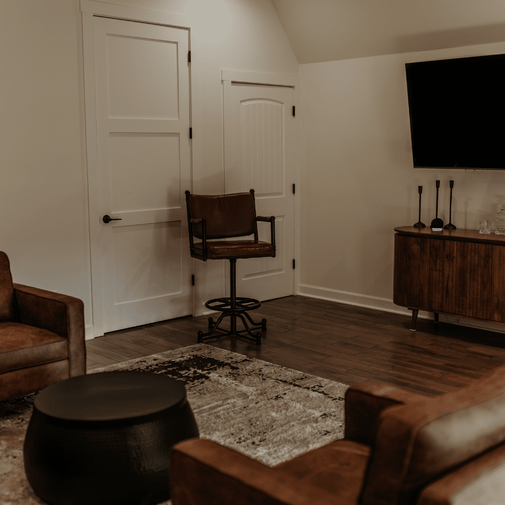 Lounge seating area with leather chairs and TV in groom’s gallery at Grahams Estate Gallatin TN