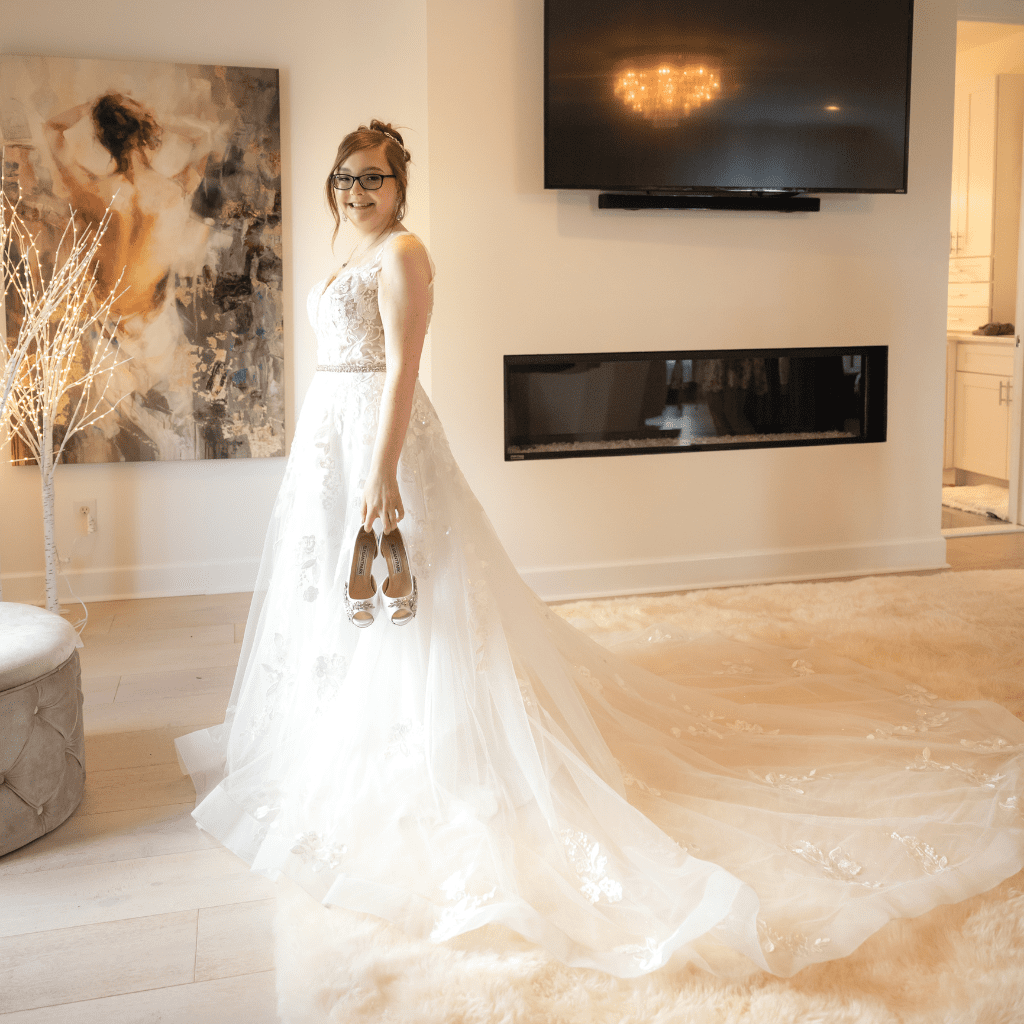 Bride in wedding gown holding shoes in suite at Grahams Estate Gallatin TN