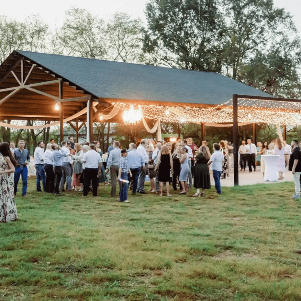 Guests enjoying a wedding reception under string lights at the Grahams Estate pavilion in Gallatin Tennessee