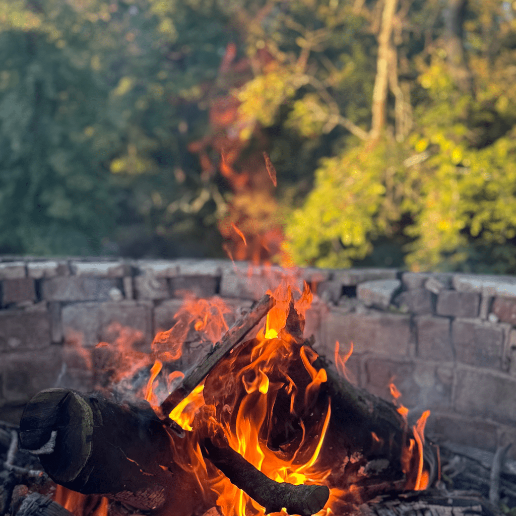 Outdoor brick fire pit with burning logs at Grahams Estate Gallatin TN