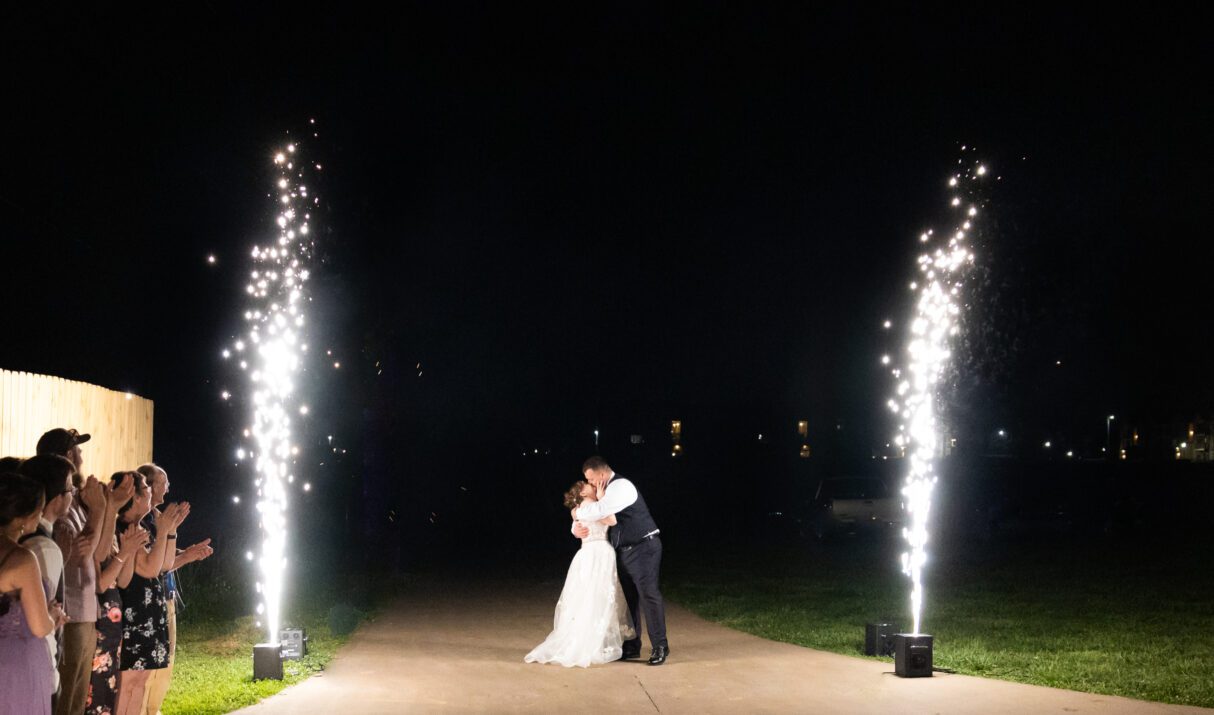 Bride and groom hugging behind fireworks at Grahams Estate Gallatin