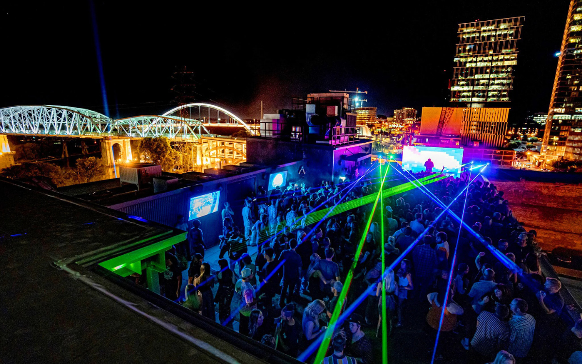 Group on a rooftop bar overlooking Broadway in Nashville at night