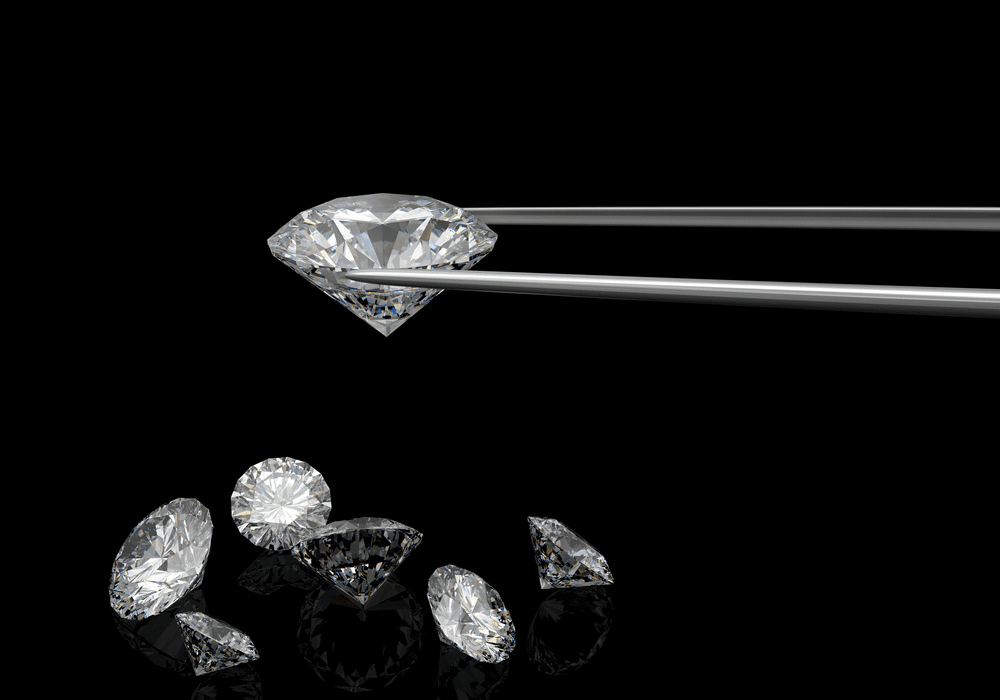 Jeweler examining loose diamonds under studio lighting