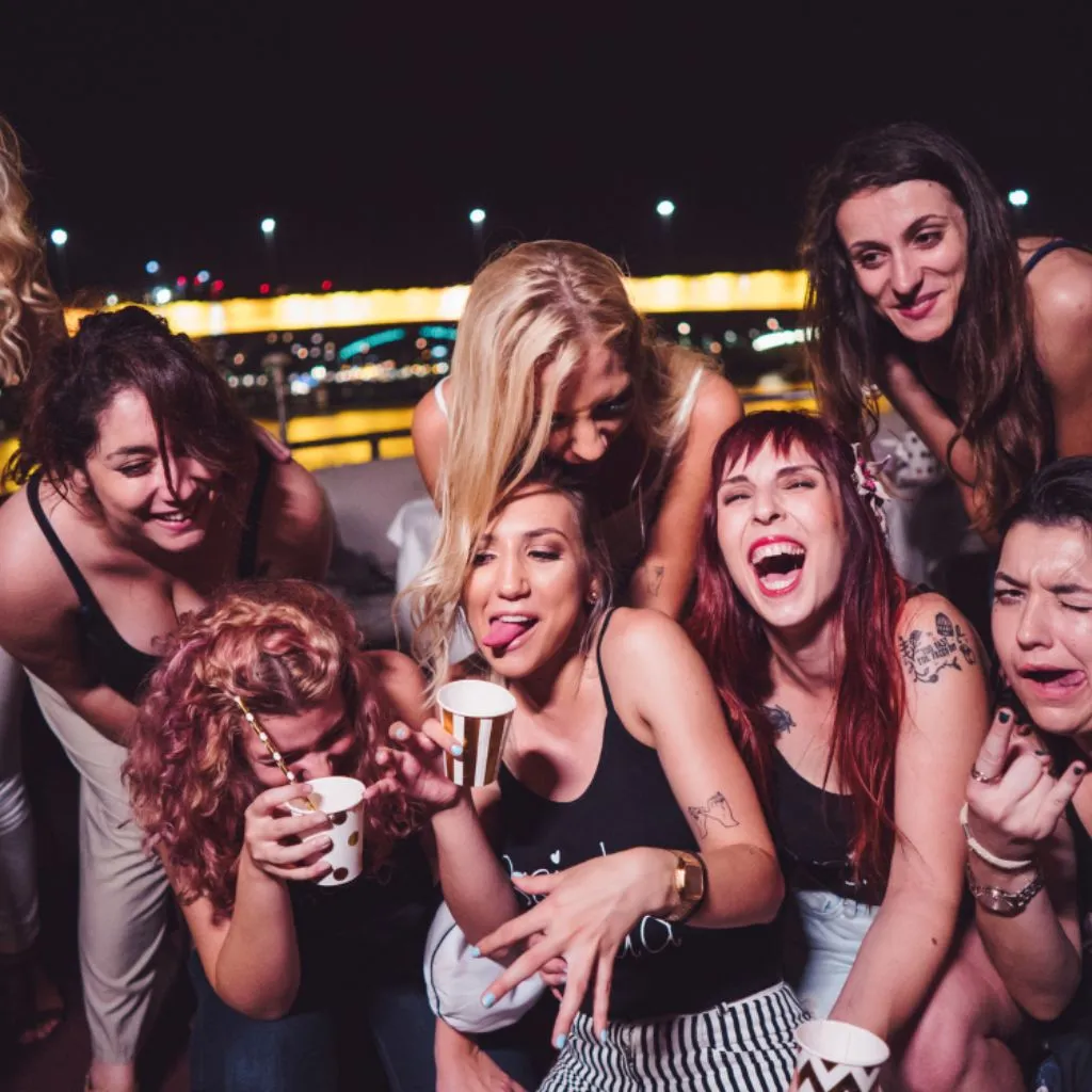 Friends laughing and drinking at a bachelorette party in Nashville TN at night