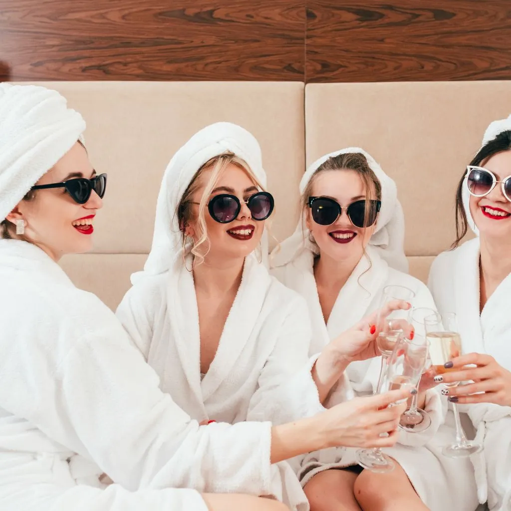 Bridal party in robes and sunglasses toasting champagne at a Nashville TN bachelorette party