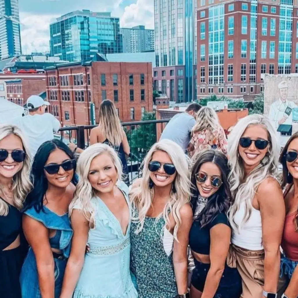 Group of women posing on a Nashville rooftop during a bachelorette party in Tennessee