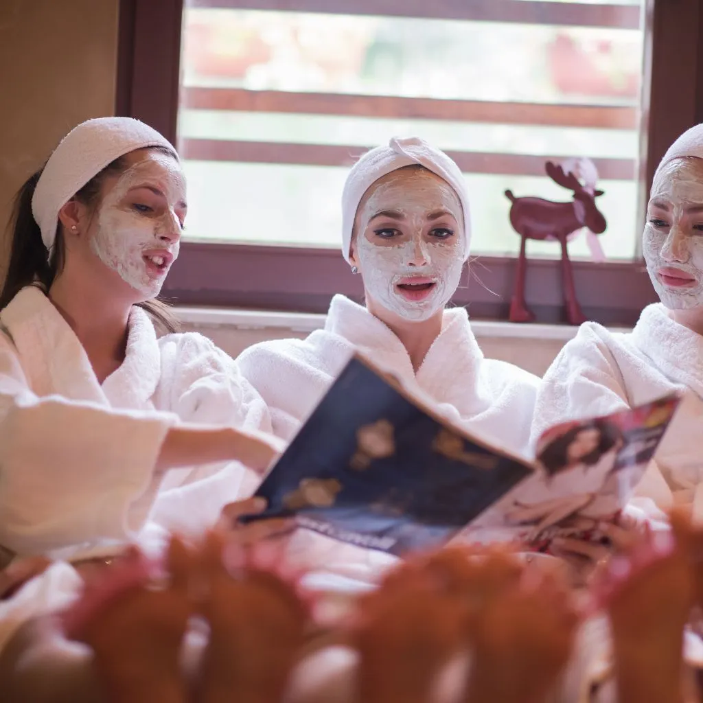 Bridal party laughing together with cucumber eye masks during spa day