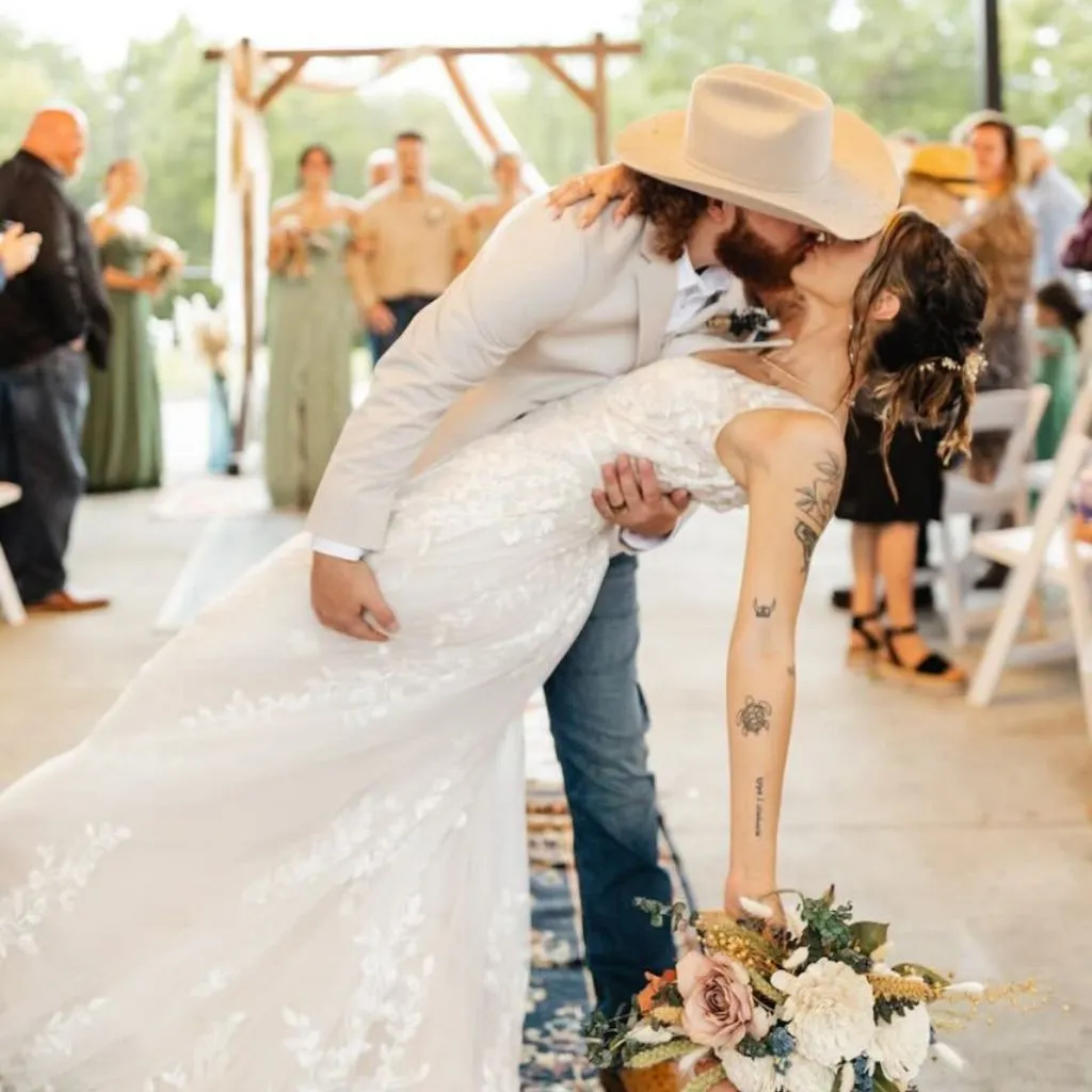 Groom in cowboy hat dipping the bride for a kiss at Grahams Estate wedding venue in Gallatin TN.
