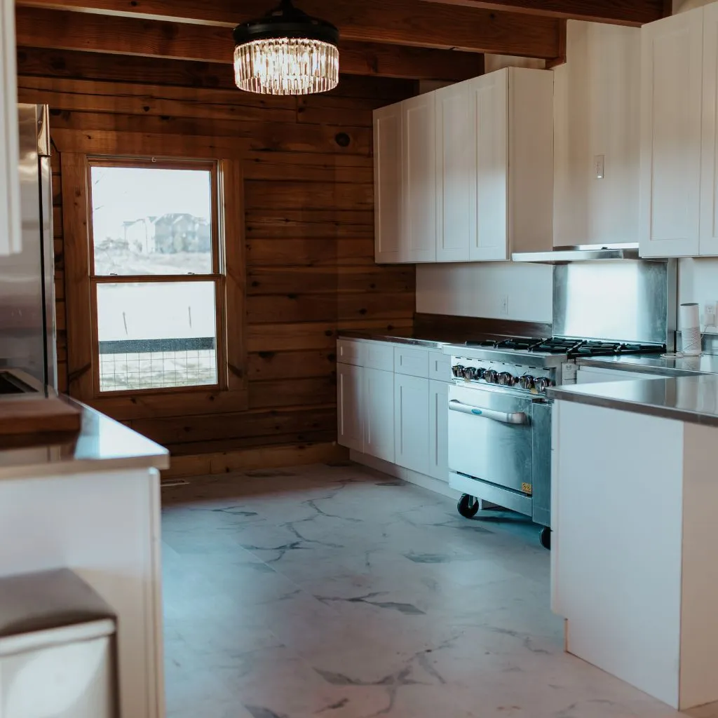 Full kitchen inside the Grahams Estate bridal suite with white cabinetry and wood walls