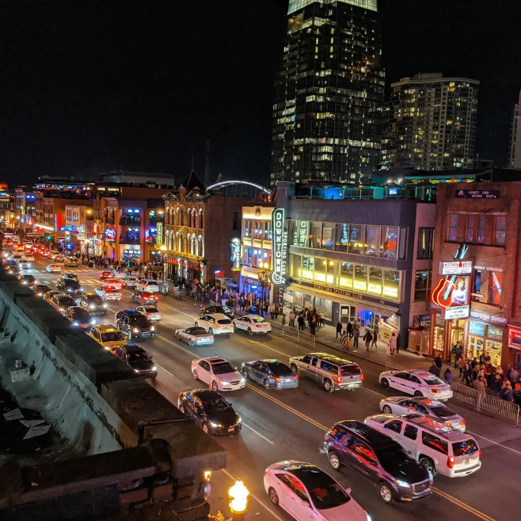 Rooftop bar overlooking Broadway in downtown Nashville with neon lights and spring nightlife