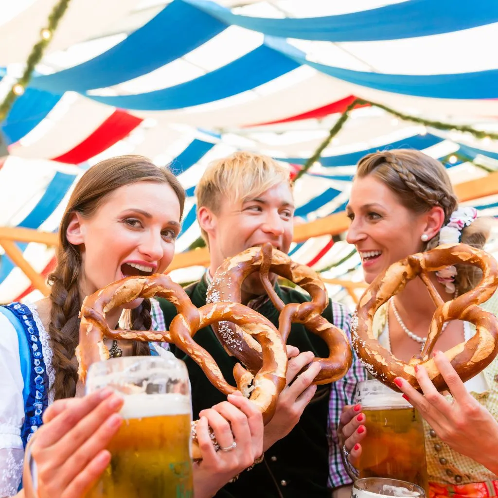Friends enjoying pretzels and beer at a Nashville Oktoberfest celebration