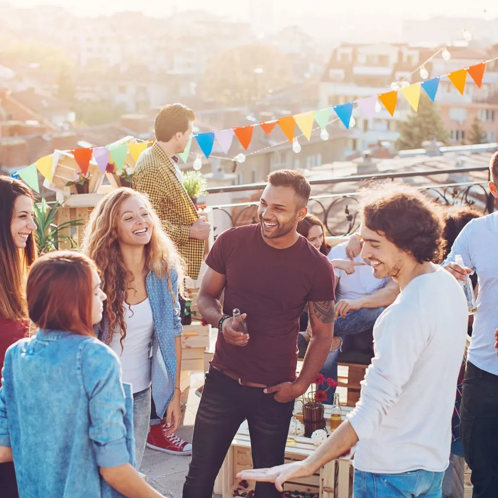 Friends at a rooftop party at sunset overlooking downtown Nashville
