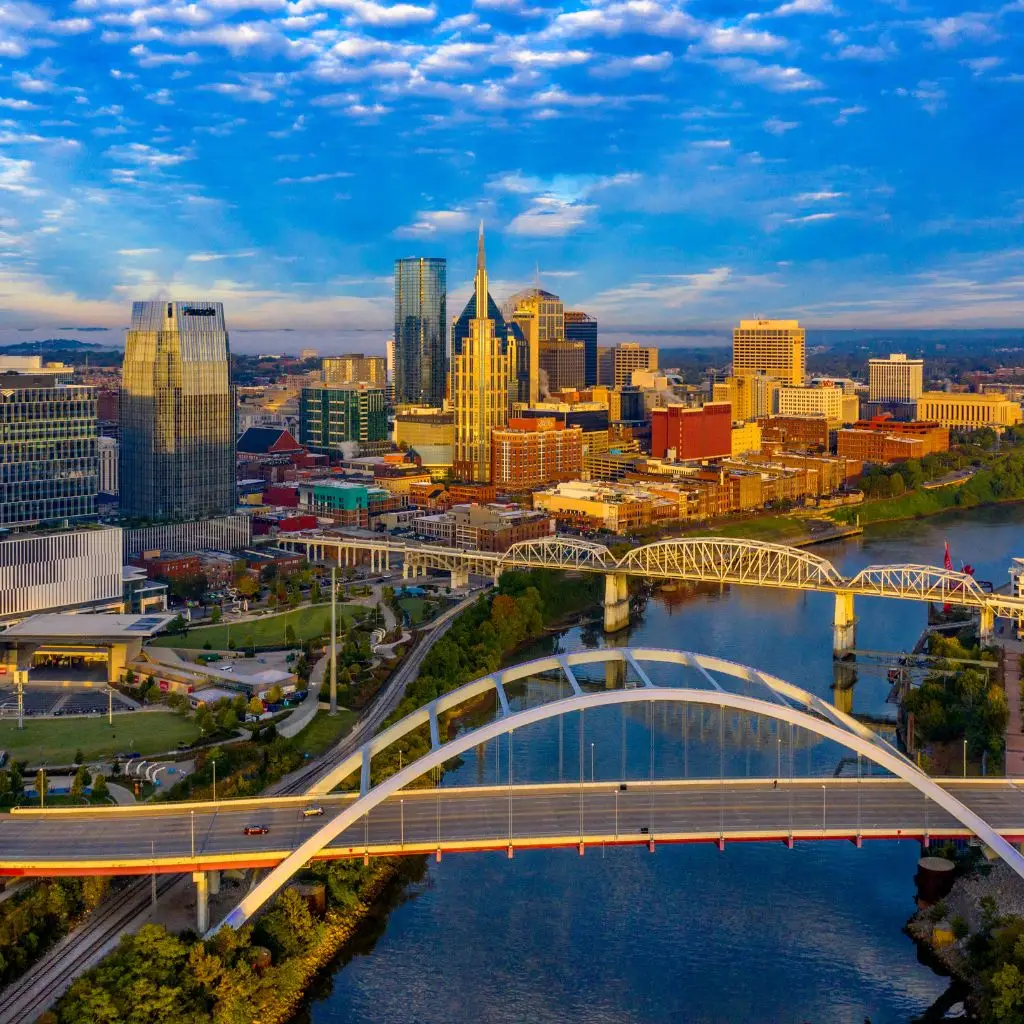 Aerial view of downtown Nashville at sunrise with bridges and the Cumberland River.