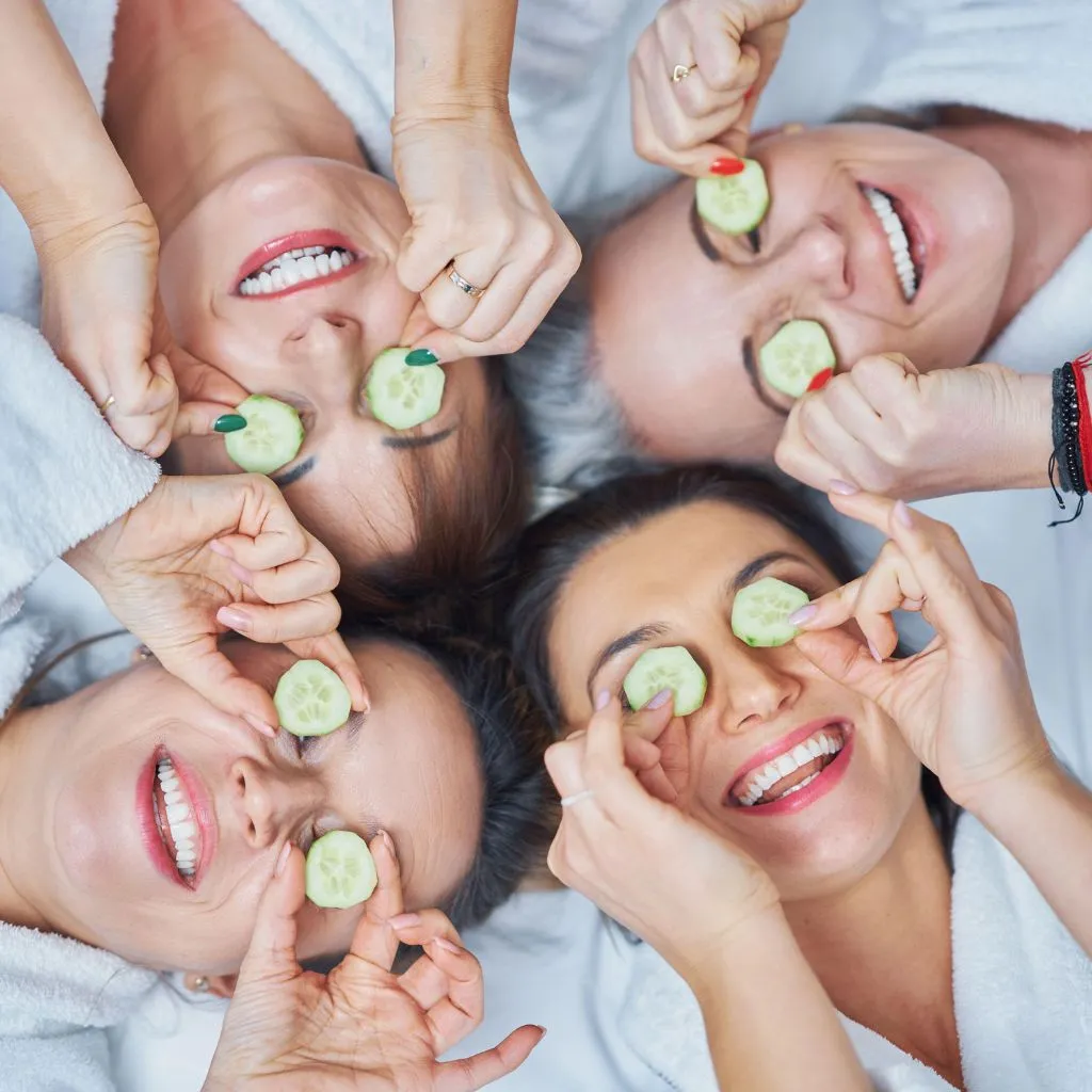 Bridesmaids in white robes dancing and celebrating on the wedding morning