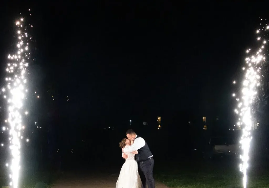 Bride and groom sharing a kiss during a nighttime sparkler exit at Grahams Estate in Gallatin TN.
