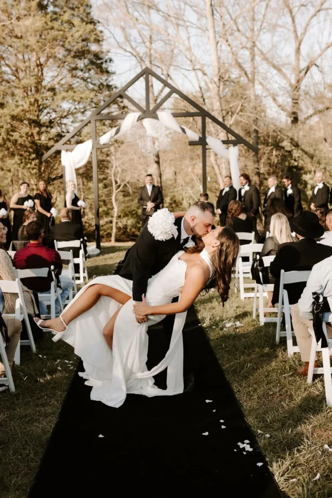 Groom dipping bride for a kiss during outdoor wedding ceremony at Grahams Estate in Gallatin TN