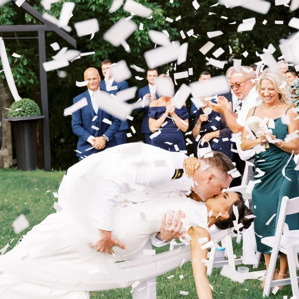 Bride and groom sharing a confetti-filled kiss during their ceremony at a wedding venue in Gallatin TN.