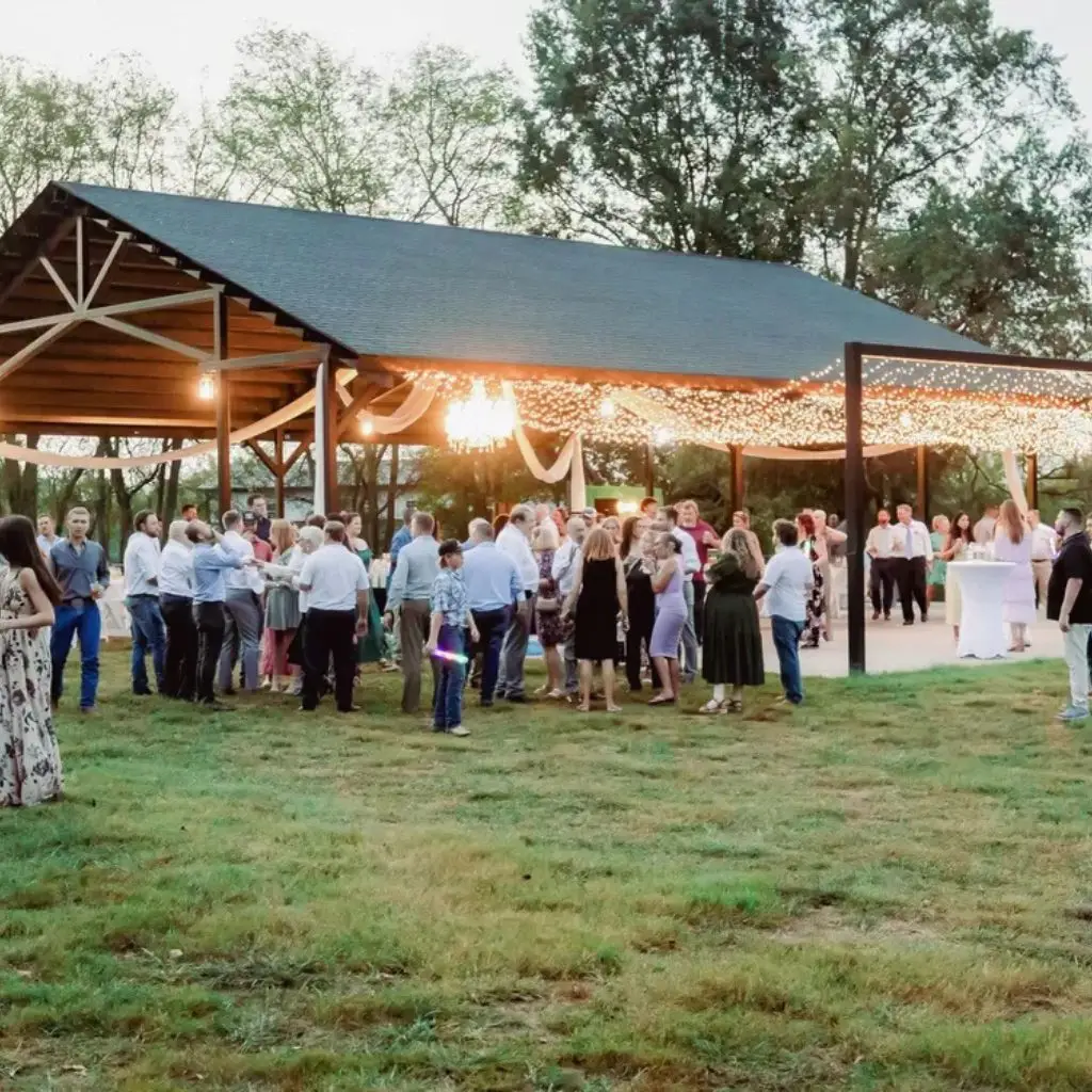 Guests enjoying an outdoor evening reception under a lighted pavilion at a wedding venue in Gallatin TN.