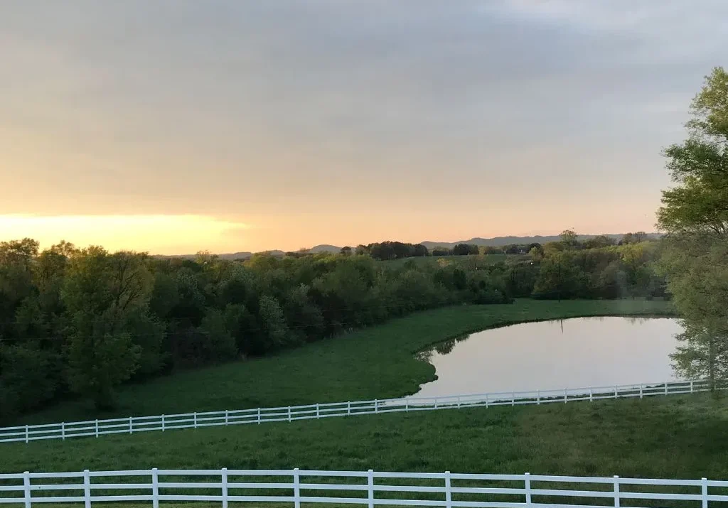 Sunset view overlooking the pond and rolling fields at a wedding venue in Gallatin TN.
